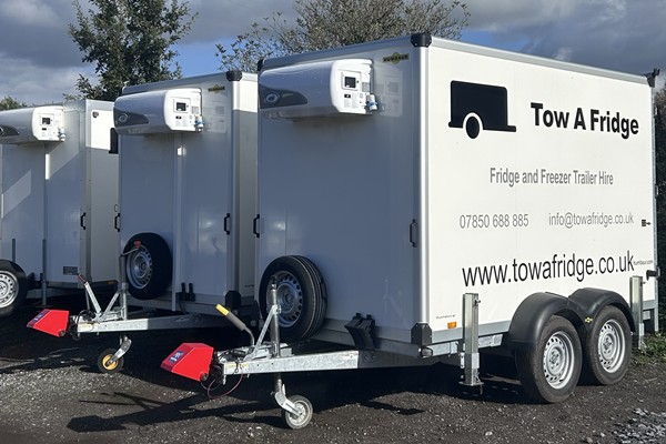 Three fridge and freezer trailers for hire parked in a row.