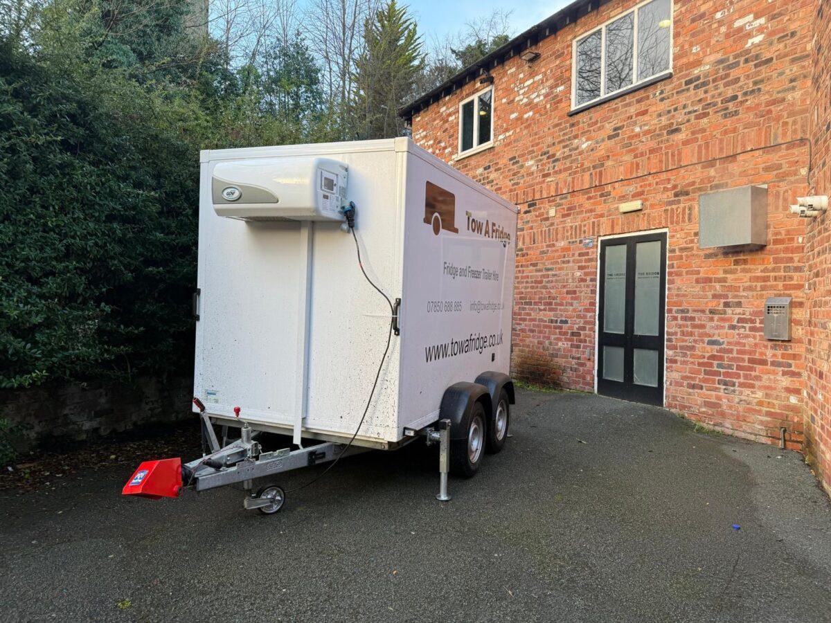 A refrigerated trailer parked in a driveway.