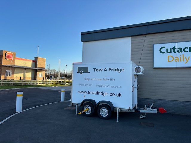 Tow A Fridge trailer parked outside a building.